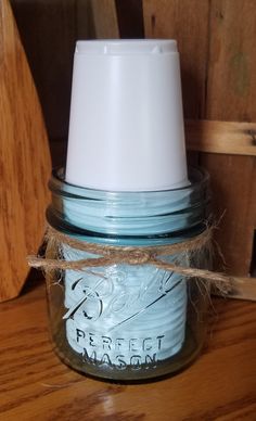 a blue jar with a white lid sitting on top of a wooden table