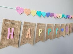 a happy birthday banner with hearts hanging from it's sides and the words happy birthday spelled in multicolored letters