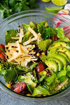 a salad with avocado, strawberries and other ingredients in a glass bowl