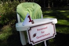 a lawn chair that is sitting in the grass with a sign on it saying reserved for quarteback