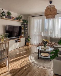 a living room filled with furniture and a flat screen tv on top of a wooden floor