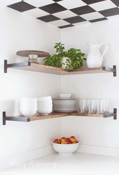 two open shelving shelves with plates and bowls on them in a white kitchen area