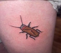 a small bug tattoo on the thigh