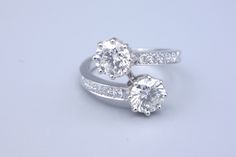 two white gold rings with diamonds on each side and one diamond set in the middle