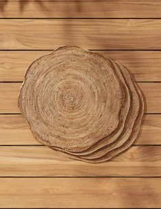 three woven plates on top of a wooden table