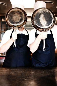 two chefs are holding up their plates in front of the camera with dirty dishes on them