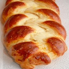 a long loaf of bread sitting on top of a white tablecloth covered countertop