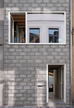 an apartment building with two windows on the side and one door open to let in light