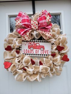 a burlock wreath that says loads of love with hearts on the front door