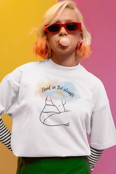 Elevate your wardrobe with our "Head in the Clouds" T-Shirt, a perfect blend of artistic design and inspirational messaging. This unique tee features a striking silhouette of a woman with clouds over her head, complemented by the uplifting slogan "Head in the Clouds." Ideal for dreamers and free spirits, this shirt is more than just clothing--it's a statement. Key Features: Design: Woman silhouette with clouds and the slogan "Head in the Clouds" Colors Available: Black, Navy, Grey, and White Mat Artistic Crew Neck Top With Text Print, Artistic Text Print Crew Neck Top, Trendy Crew Neck Tops For Artistic Expression, Graphic Tee With Letter Print For Artistic Expression, Artistic Relaxed Fit T-shirt With Letter Print, Silhouette Of A Woman, Cloud Design, Head In The Clouds, Clouds Design