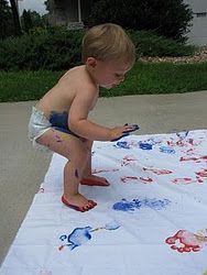 a little boy standing on top of a white blanket