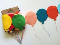 there are many different colored hot air balloons in the shape of kites on this table