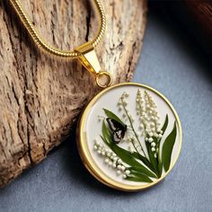 Celebrate the month of May with our exquisite birth flower necklace featuring the delicate and beautiful Lily of the Valley plant and a charming butterfly. The photo is expertly printed with a 3D effect, giving it a unique and striking pressed flower look. Perfect as a May birthday gift, bridesmaid gift (choose from 12 different types), Mother's Day surprise, Christmas present, or anniversary token of love. Made with our patent-pending technology, this necklace is crafted from high quality surgi Flower-shaped Butterfly Charm Jewelry Gift, Flower Butterfly Charm Jewelry Gift, Botanical Birth Flower Necklaces For Mother's Day, Flower Shaped Butterfly Charm Jewelry Gift, Flower Shaped Butterfly Charm Jewelry As Gift, Nature-inspired Birth Flower Round Pendant Necklace, Nature-inspired Flower Necklace With Round Pendant, Nature-inspired Round Pendant Flower Necklace, Botanical Birth Flower Round Pendant Necklaces