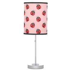 a pink lamp with ladybugs on it and a black shade for the lampshade