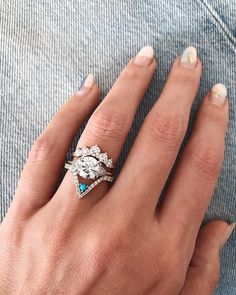 a woman's hand with two rings on top of her finger and the other one has