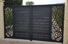 an iron gate with decorative designs on the top and bottom part, in front of a house