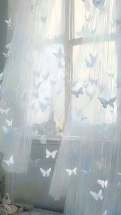 a window with sheer curtains and white butterflies on it