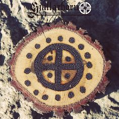 a piece of wood that has been carved into the shape of a cross and is sitting on top of some rocks