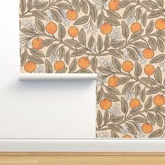 an orange tree with leaves and flowers on a wallpapered background in a room