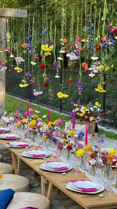 a long table with plates and flowers hanging from it