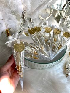 a person holding some white and gold decorations