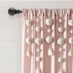 a curtain with tassels and pom poms hanging from it's side