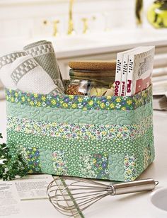 an image of a kitchen counter with magazines and utensils in the basket on it