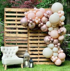 a chair sitting next to a wooden pallet with balloons on it