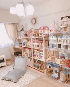 a living room filled with lots of toys and shelves full of dollhouse houses on top of them