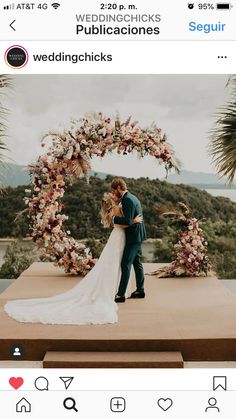 a bride and groom standing under an arch with flowers