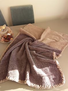 a table topped with two blankets and a bowl of food on top of the table