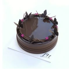 a chocolate cake decorated with pink flowers and leaves