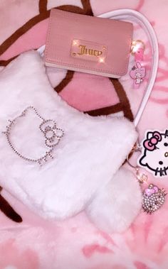 a hello kitty purse sitting on top of a pink blanket