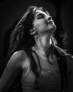 black and white photograph of a woman with her eyes closed, looking up at the sky