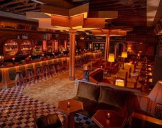 the inside of a restaurant with checkered flooring and wooden walls, large chandeliers