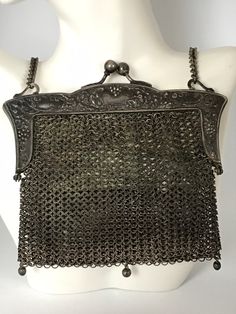 "This sweet little silver chain mail bag is truly a collector's gem. Hand crafted chainmail mesh body attached to a 2 piece hinged kiss-lock closure frame all crafted in German Silver. Beautiful but simple floral pattern on the frame. Lined in white kidglove leather, this lining is worn and soiled. Bag is otherwise in great condition. Measures approx. 5\" x 4.5\". Chain has a 7\" drop." Silver Metal Rectangular Bag, Silver Chainmail Bag For Everyday Use, Elegant Silver Bag With Chainmail Detail, Chainmail Bag, Silver Metal Chain Link Bag, Elegant Silver Chainmail Bag, Luxury Elegant Chainmail Bag, Silver Chainmail Evening Bag, Vintage Silver Handmade Bag