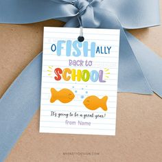 a blue ribbon tied to a brown box with a tag on it that says, fish ally back to school