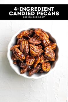 a bowl filled with candied pecans on top of a white table