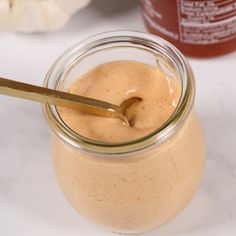 a jar filled with peanut butter sitting on top of a table next to a spoon