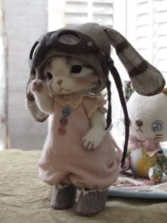 a cat doll is standing next to a stuffed bunny