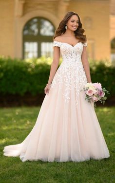 a woman in a wedding dress standing on the grass