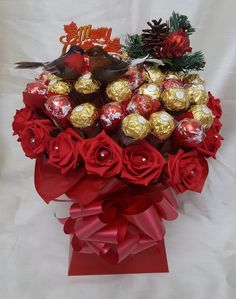 a bouquet of red roses and chocolates in a vase