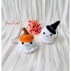 two crocheted keychains with faces on them, one is wearing a witches hat