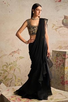 Black pre-draped saree with frill border. Paired with net gold sequin, bead, cutdana embroidered blouse in floral pattern.
Components: 2
Pattern: Embroidery
Type Of Work: Sequin, bead, cutdana
Neckline: Square neck
Sleeve Type: Sleeveless
Fabric: Saree: Chiffon, Organza, Blouse: Net
Color: Black
Other Details: 
Back cut-out blouse
Frill border
Occasion: Reception - Aza Fashions Ridhi Mehra Saree, Black Net Blouse, Sabyasachi Dresses, Black Sari, Traditional Dressing, Farewell Sarees, Ridhi Mehra, Net Blouse, Elegant Wear