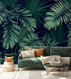 a living room with palm leaves on the wall and green couches in front of it