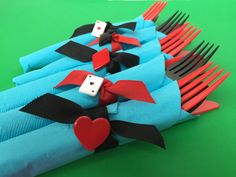 a close up of a bunch of forks with hearts on them and two dices in the middle