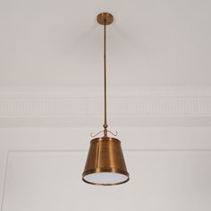 a light fixture hanging from the ceiling in a room with white walls and trimmings