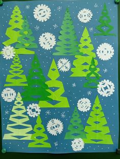 a christmas tree made out of construction paper on a blue background with white snowflakes