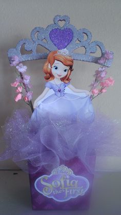 there is a princess doll in a purple box with pink flowers and a tiara