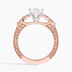 a rose gold engagement ring with a princess cut diamond in the center and filigrees around the band